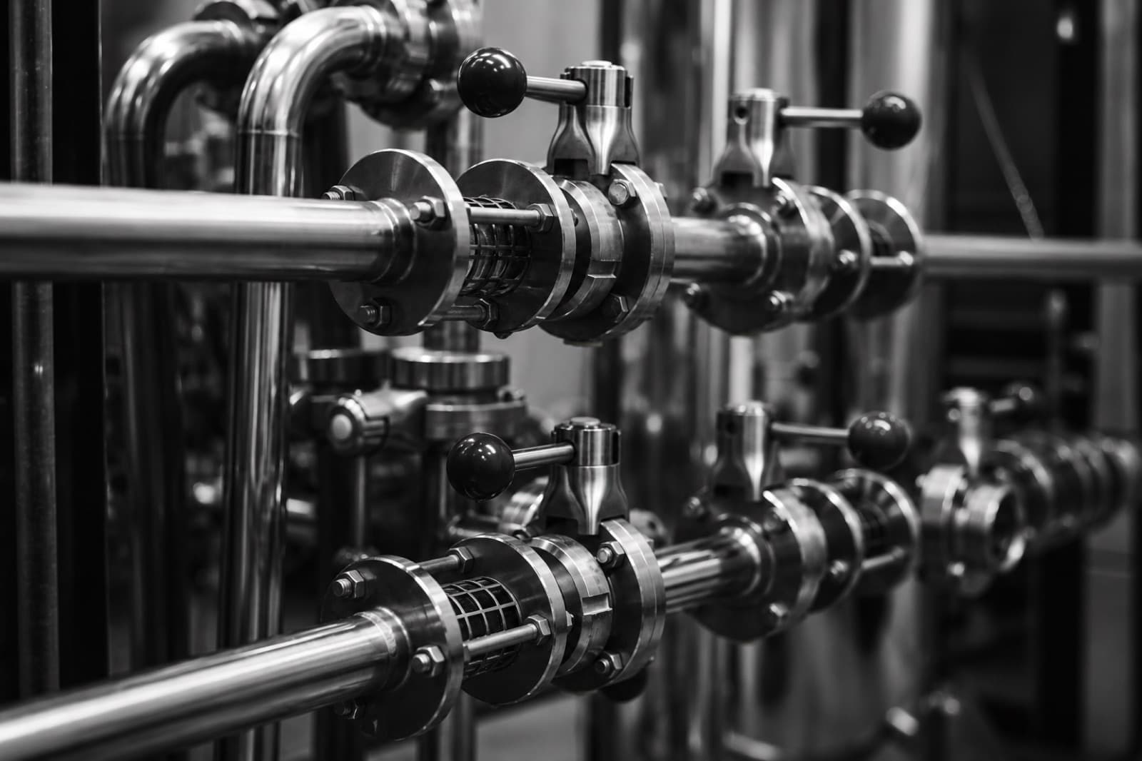 Close-up detail of polished stainless steel commercial pipework and valves